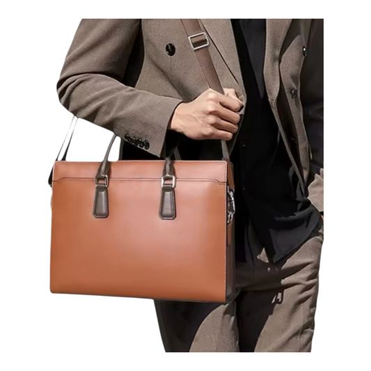 Brown leather messenger bag held by a person wearing a suit.