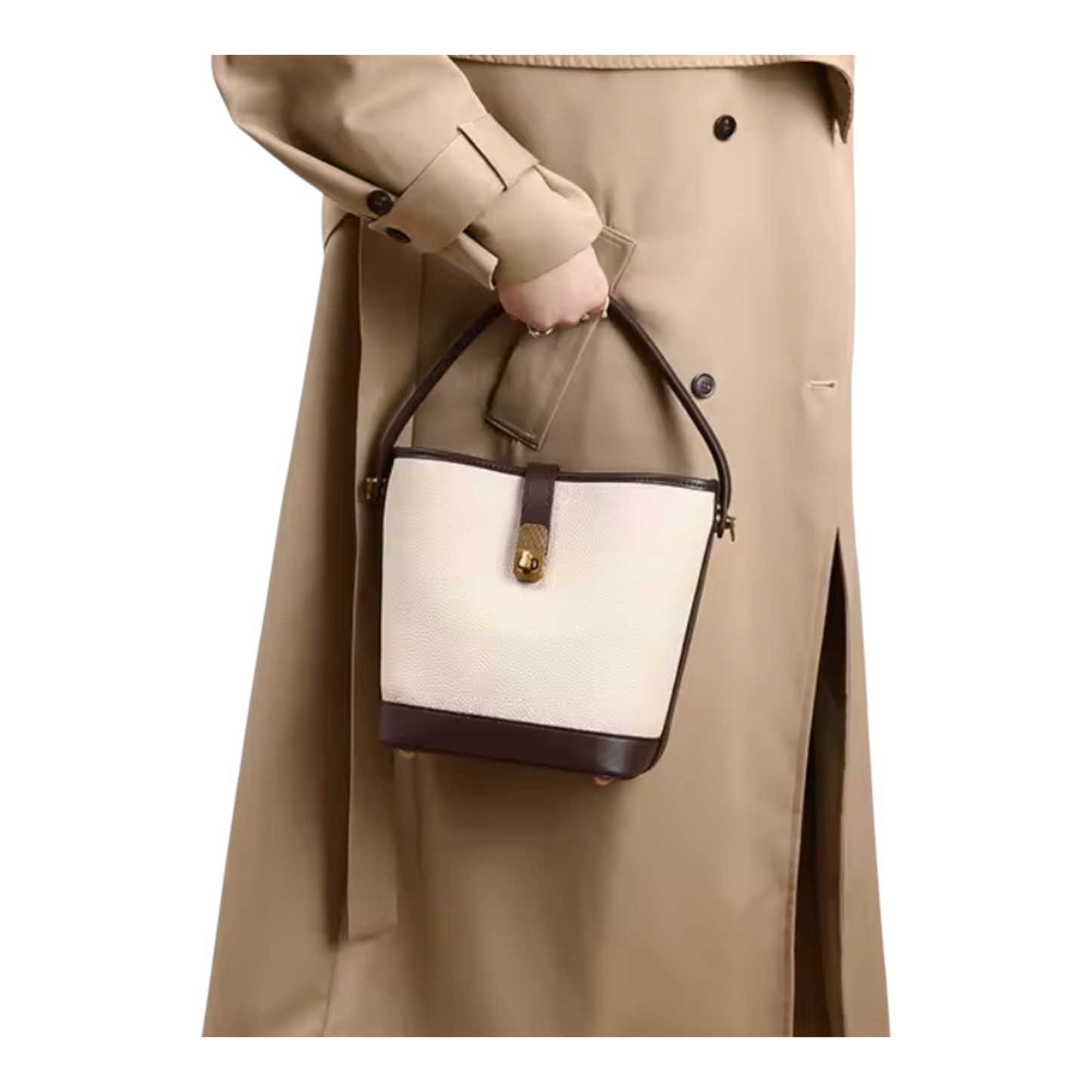 Person holding a beige and brown handbag with a beige coat.