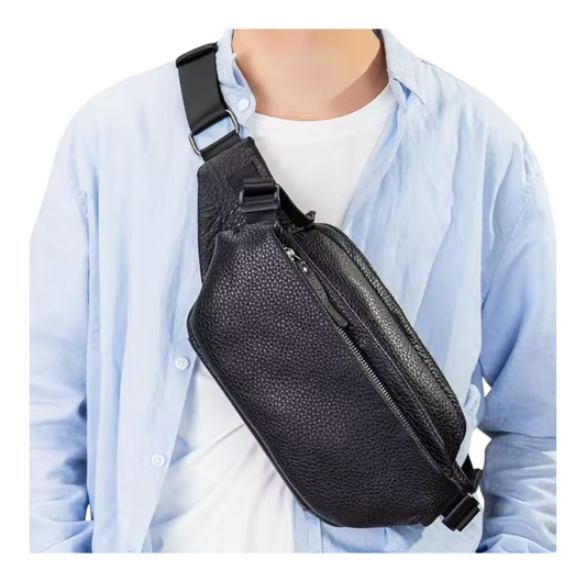 Person wearing a black leather sling bag over one shoulder on a white background