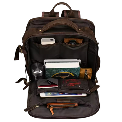 Brown leather backpack with various items inside on a white background
