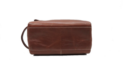 Bottom angle of a brown leather toiletry bag on a white background