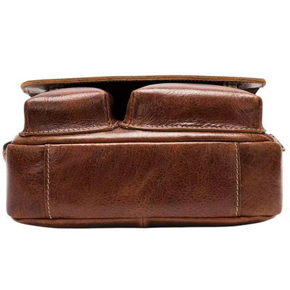 Dark brown leather sling bag with a flap on a white background