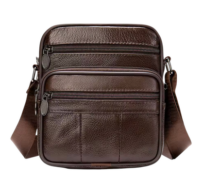 Brown leather crossbody bag with multiple zippers on a white background