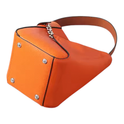 Bottom view of an orange handbag with a chain detail on a white background