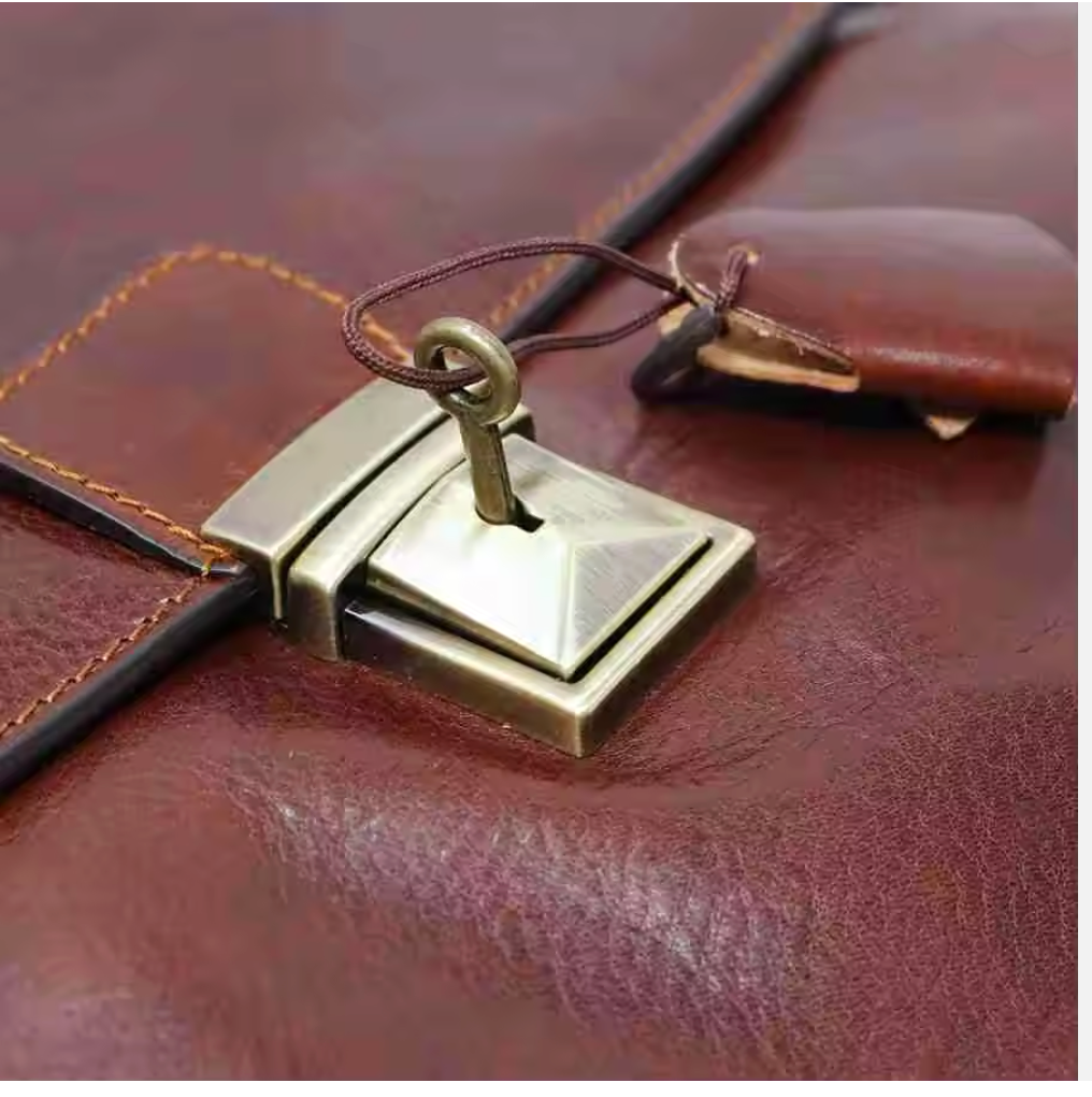 Close-up of a brown leather bag with a gold metal clasp.