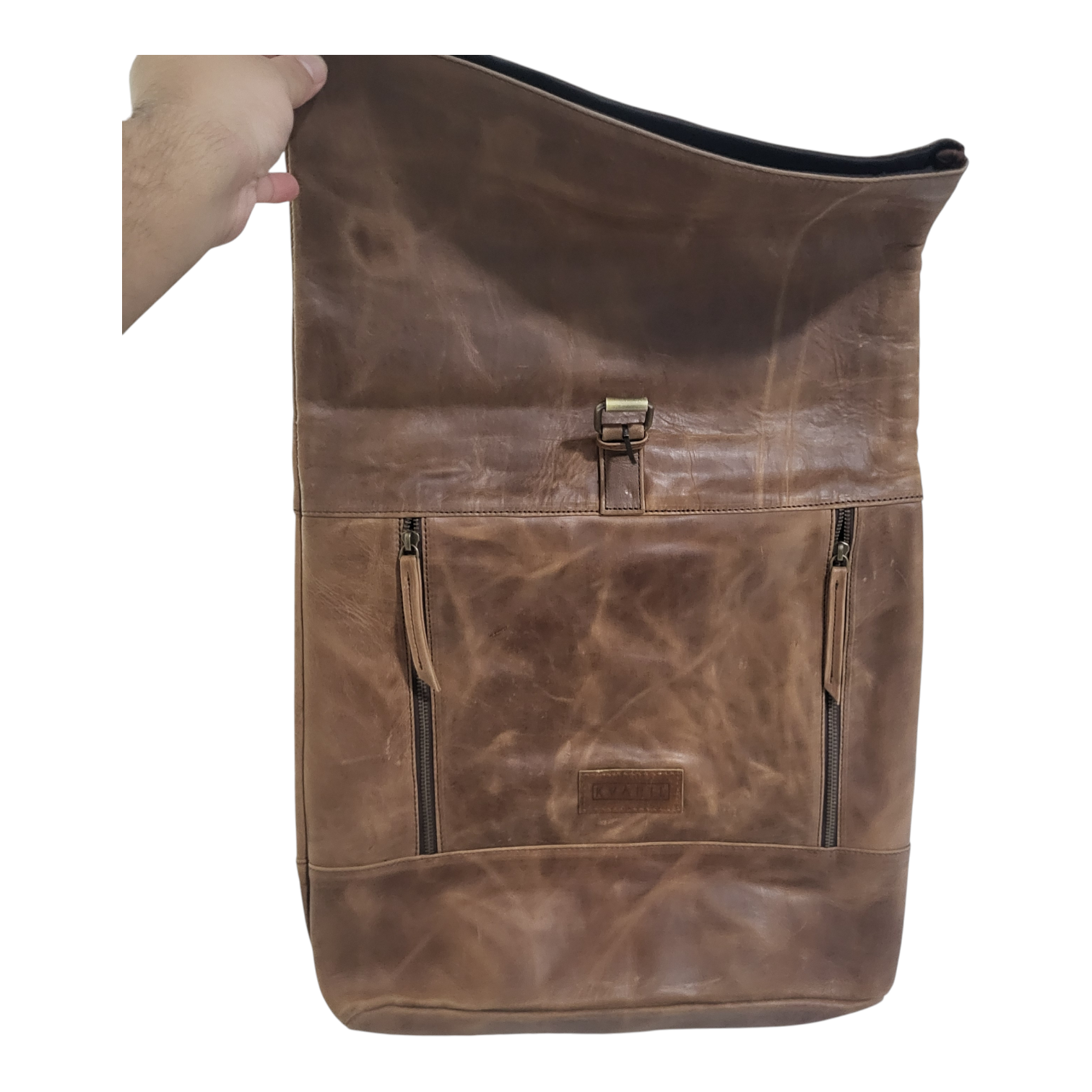 Full View of a brown leather backpack held by a hand on a white background