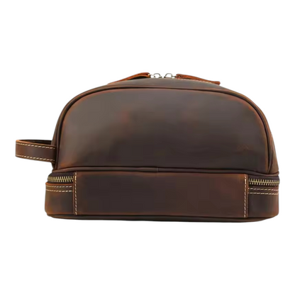 Back view of a brown leather toiletry bag with stitching details on a white background